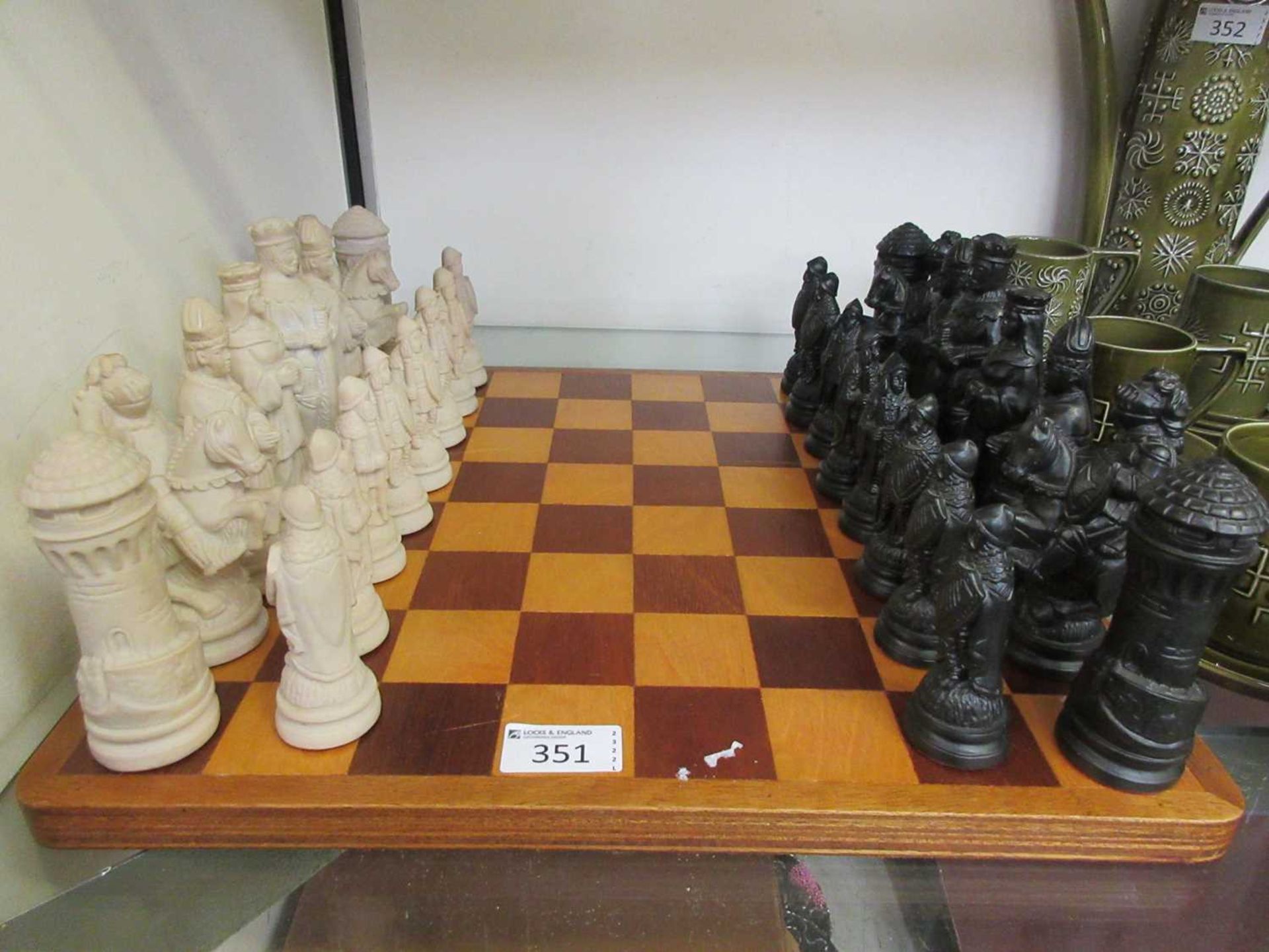 A wooden chess board with a set of moulded chess pieces