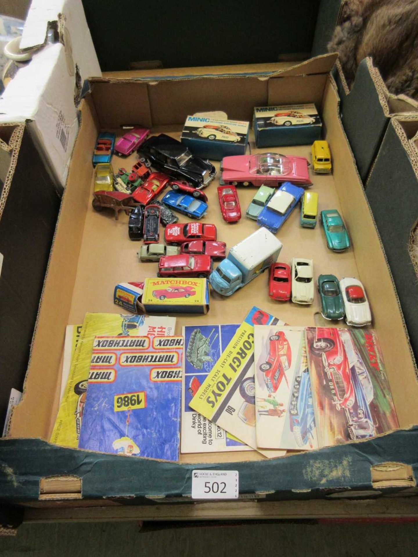 A tray containing a quantity of diecast cars and pamphlets by Matchbox etc.