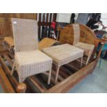 A pair of wicker chairs together with a matching occasional table.