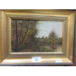 A framed oil on board of countryside signed bottom right