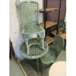 A green PVC garden circular table with a pair of matching chairs