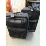 Two black canvas suitcases together with one other