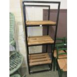 A black metal industrial shelving unit with pine shelving