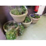 Four PVC stone effect garden planters with flowers.