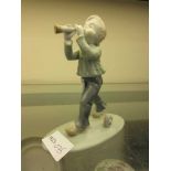 A Spanish style ceramic figurine of young boy playing instrument