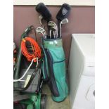 A green and blue golf bag containing an assortment of golf clubs