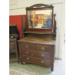An early 20th century walnut dressing chest, the bevelled mirror over two short and two long