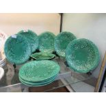A selection of green glazed ceramic plates with grape bunch design along with two leaf design plates