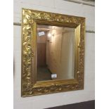 An ornate gilt framed bevel glass mirrorGilt fading in areas. No other apparent damage.