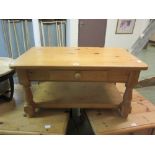 A modern pine coffee table with side drawer and under tier