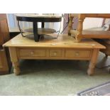 A modern pine coffee table with drawers to side