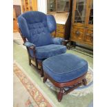 A modern cherrywood effect armchair with matching footstool in a floral patterned button back blue