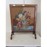 A fire screen with floral tapestry panel