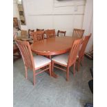 A late 20th century teak extending dining table with a set of six matching chairs