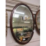 A mahogany oval bevel glass mirror