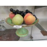 A Royal Worcester white and green glazed tazza containing a selection of faux fruit