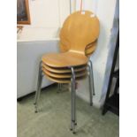 A set of four plywood and chrome based stacking dining chairs