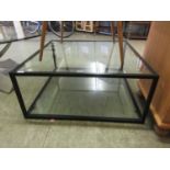 A late 20th century coffee table, the black metal frame with glass top and under tier
