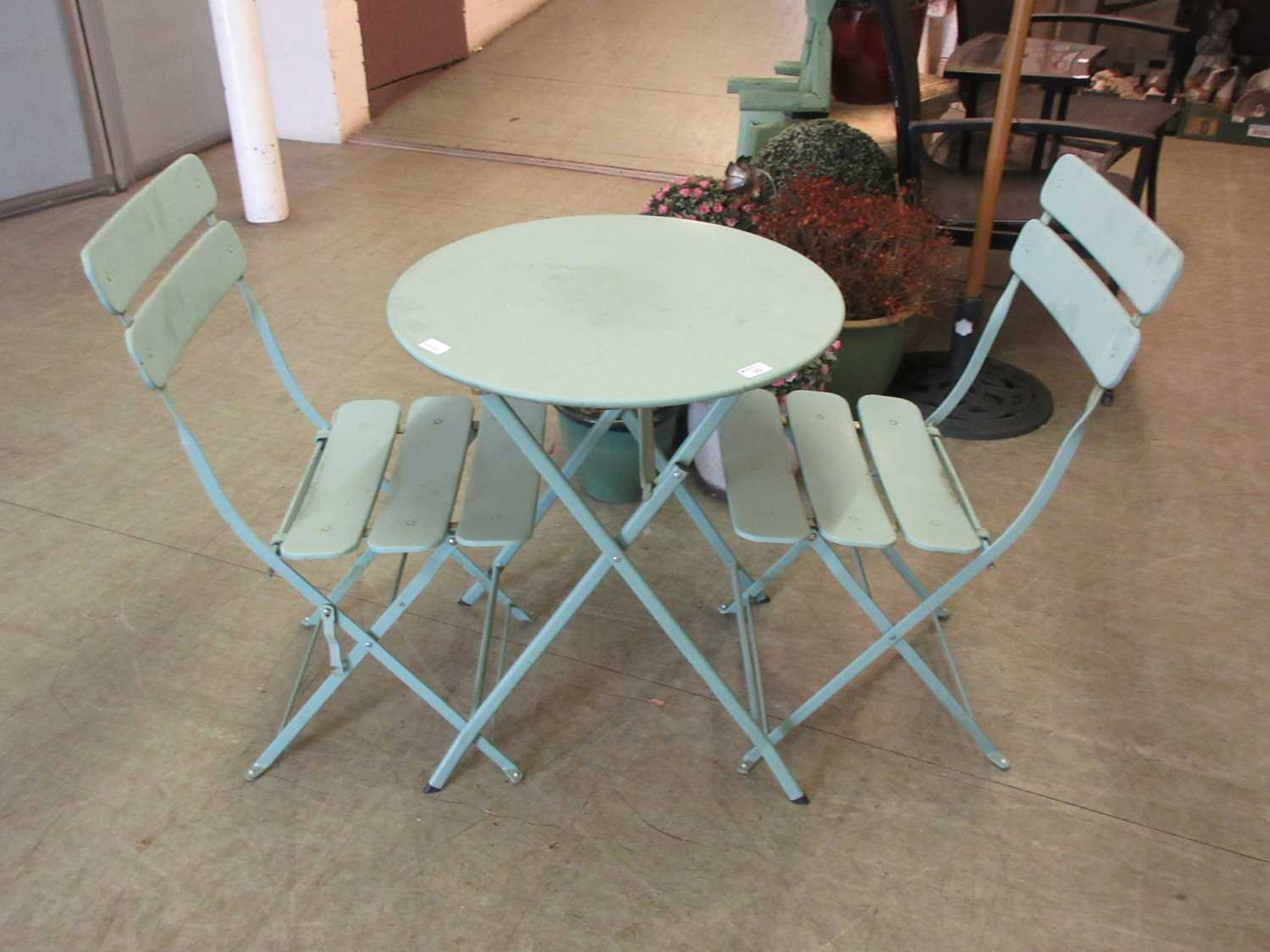 A turquoise metal folding bistro set