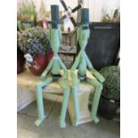A pair of green painted wooden seated figures
