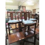 A set of four early 20th century oak framed dining chairs with floral upholstered pad seats