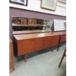 A mid-20th century teak dressing table, the mirror over the base with two cupboard doors flanking