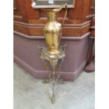 An ornate brass stand with associated ewer