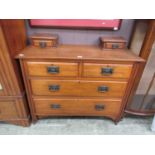 An early 20th century walnut chest of drawers with trinket drawers to top