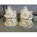 A pair of composite stone garden ornaments in the form of fantastical cottages
