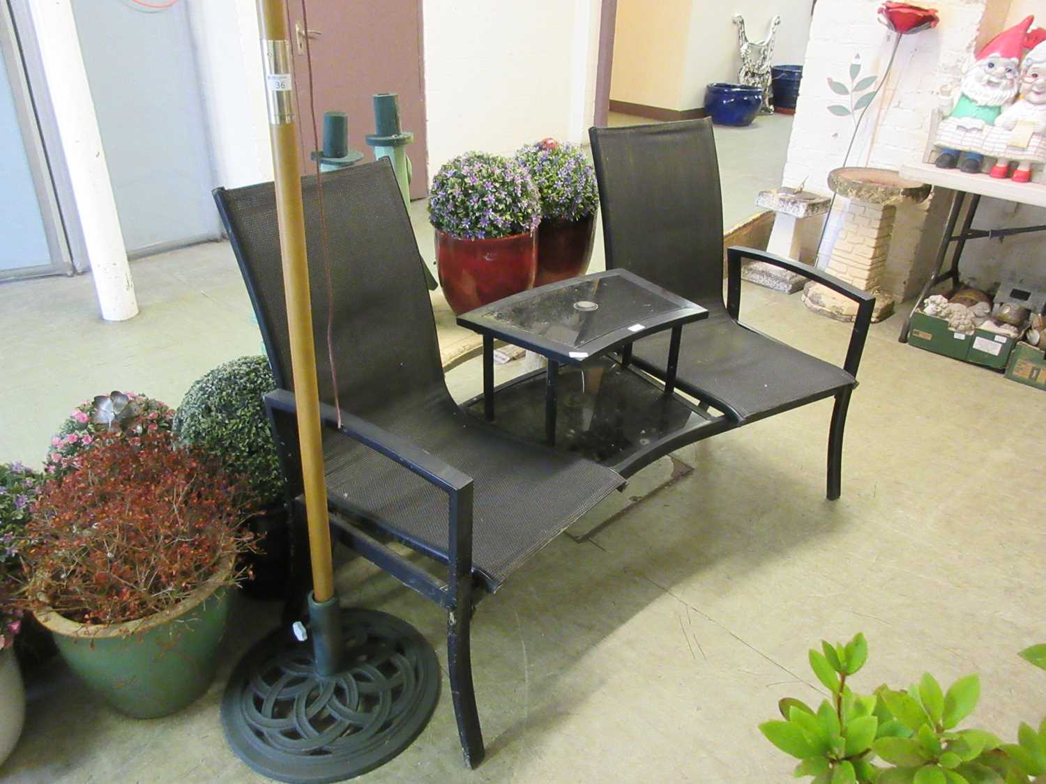 A black metal two seat bench with central table