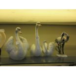 Three Lladro swans along with a Kaiser figure of a stork