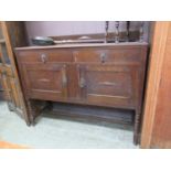 An early 20th century oak sideboard, the top over two drawers and two cupboard doors