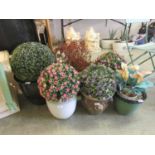 Six glazed garden pots containing artificial plants