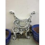 A pair of white painted cast metal bench ends