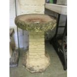 A composite stone birdbath