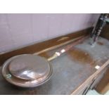 A brass and copper bed warming pan