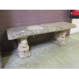 A composite stone garden bench on squirrel supports