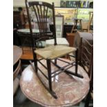 An early 20th century beech framed rocking chair with woven seat