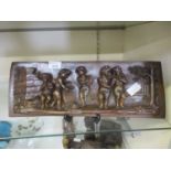 An embossed copper panel depicting music playing putti