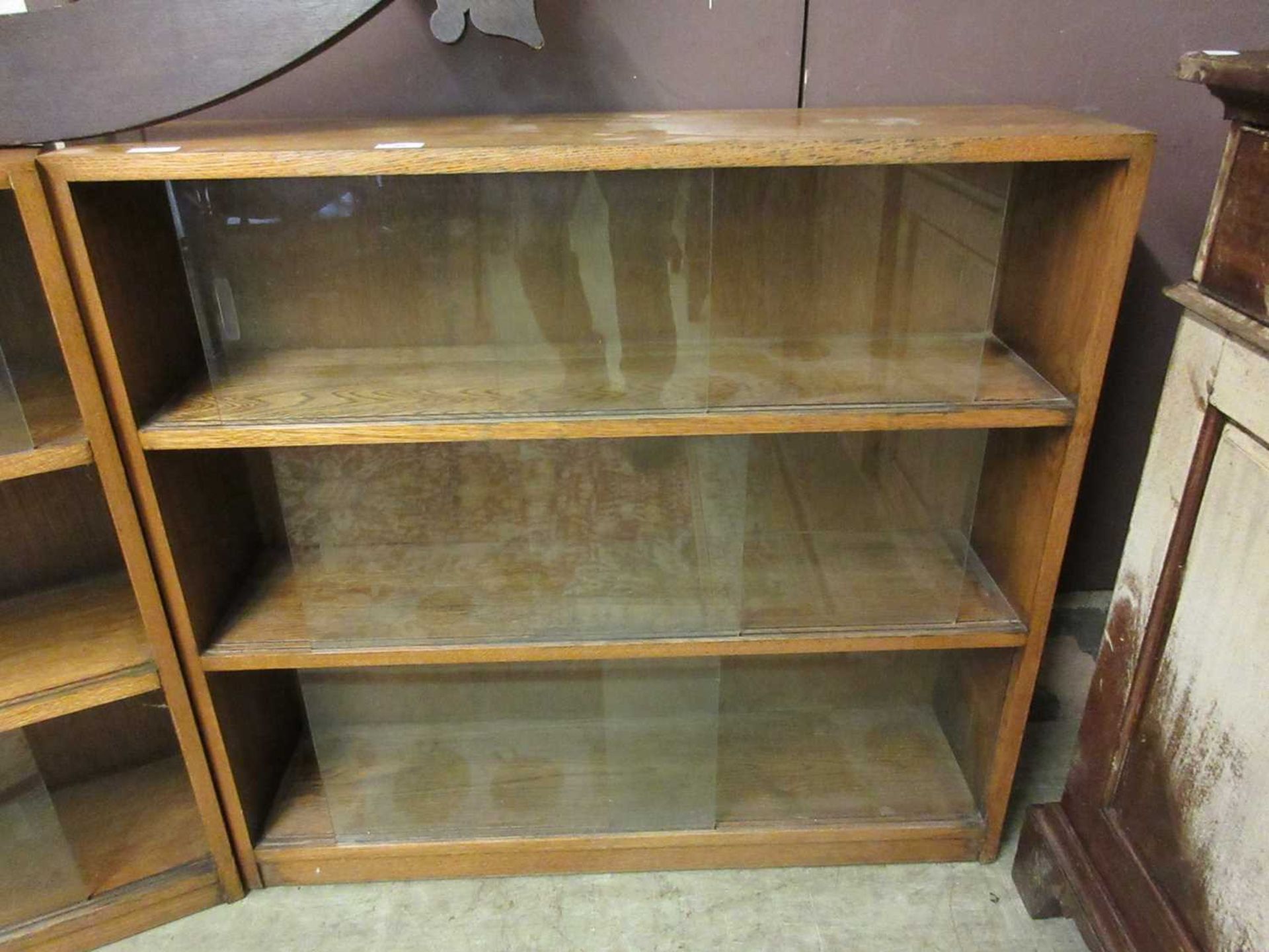 A mid-20th century oak bookcase with glass sliding doors