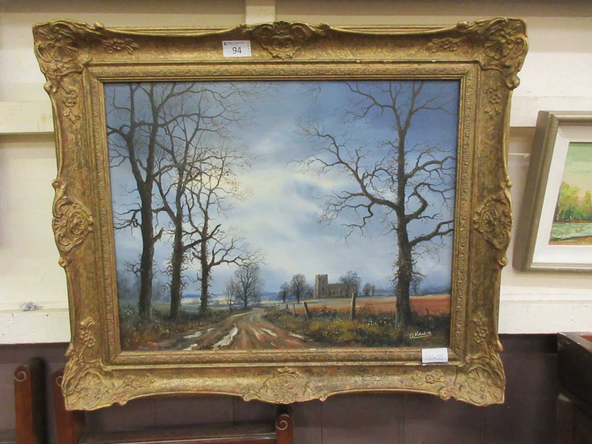 An ornate gilt framed oil on canvas of country lane scene signed C.Vokes