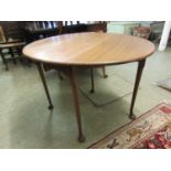 An early 20th century walnut drop leaf table, the oval top on cabriole legs