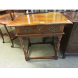 A reproduction cherrywood single drawer side table on turned legs