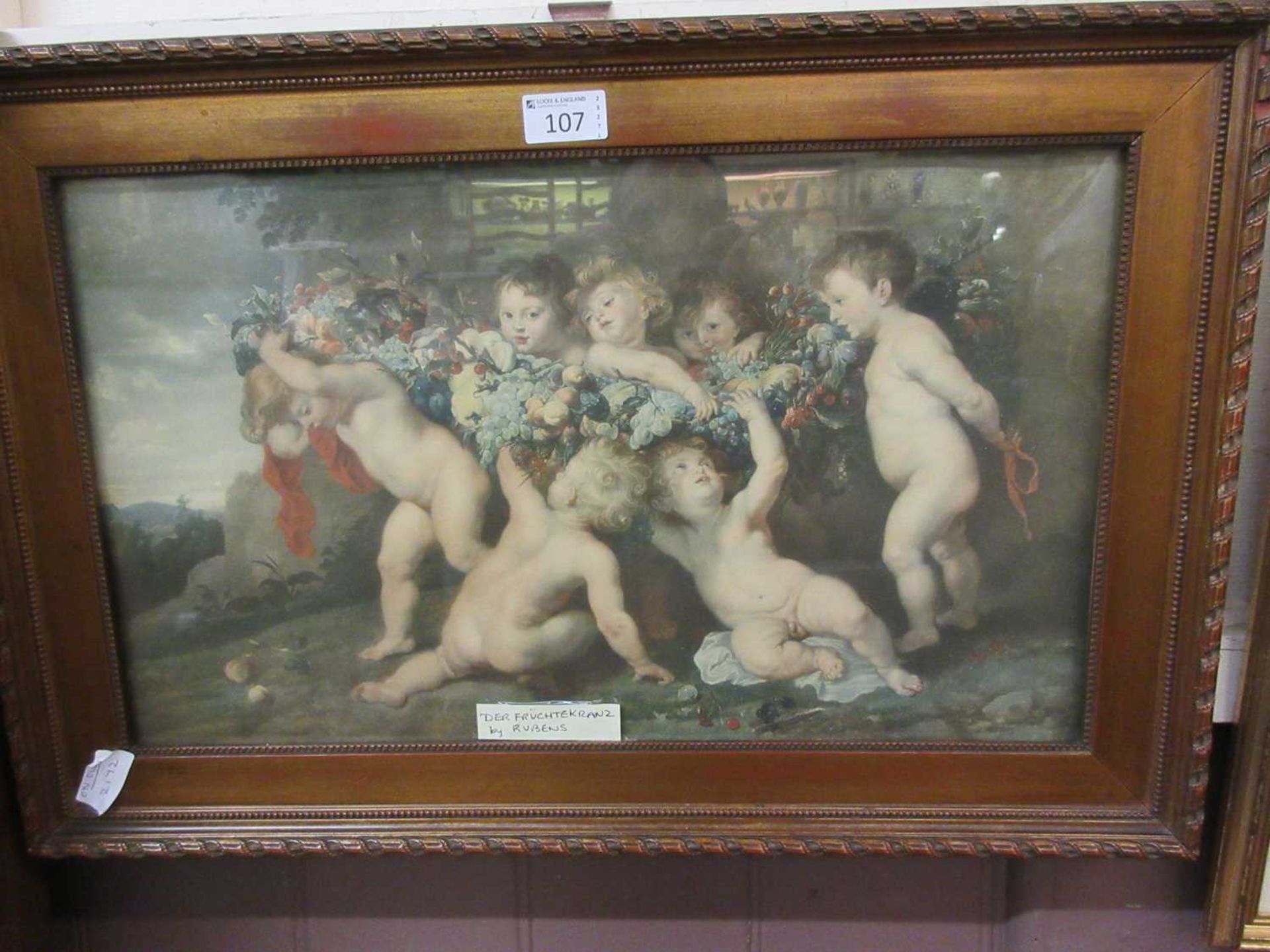 A framed and glazed print of putti holding grapes and fruit after Rubens