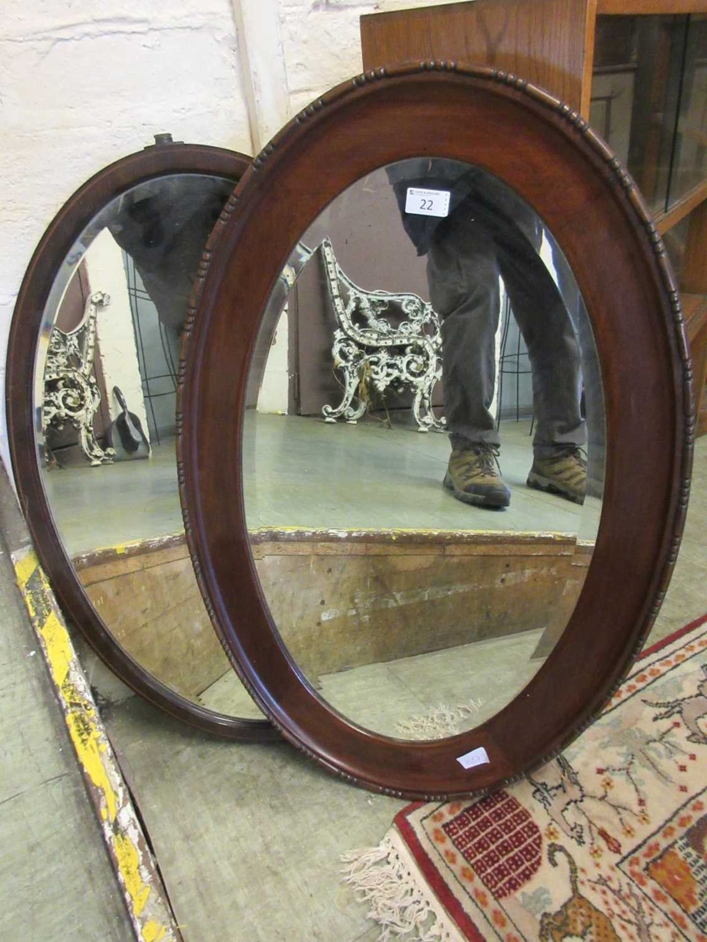 An early 20th century mahogany framed oval bevel glass mirror along with one other