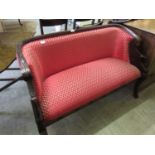 A mahogany framed two seat settee with swan carved arms upholstered in a red and gold patterned