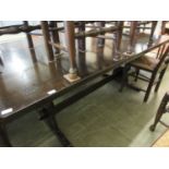 A reproduction oak dining table with trestle end supports