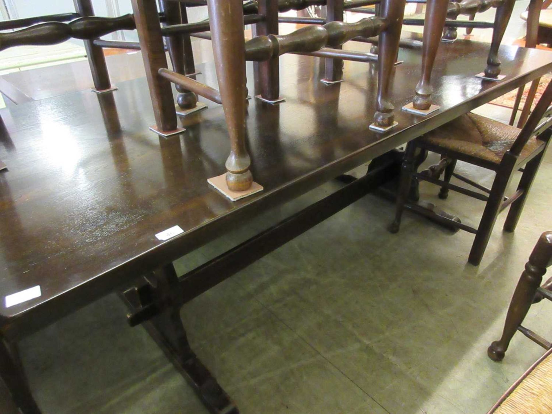 A reproduction oak dining table with trestle end supports