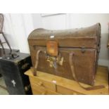 An early 20th century oil skin and leather travelling trunk with fitted interior having name J.R.