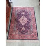 A hand woven Persian rug, the triple line border enclosing blue ground field with central medallion